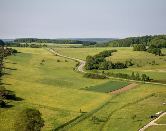 An aerial shot of farmland under the clear sky in the Eifel region, Germany